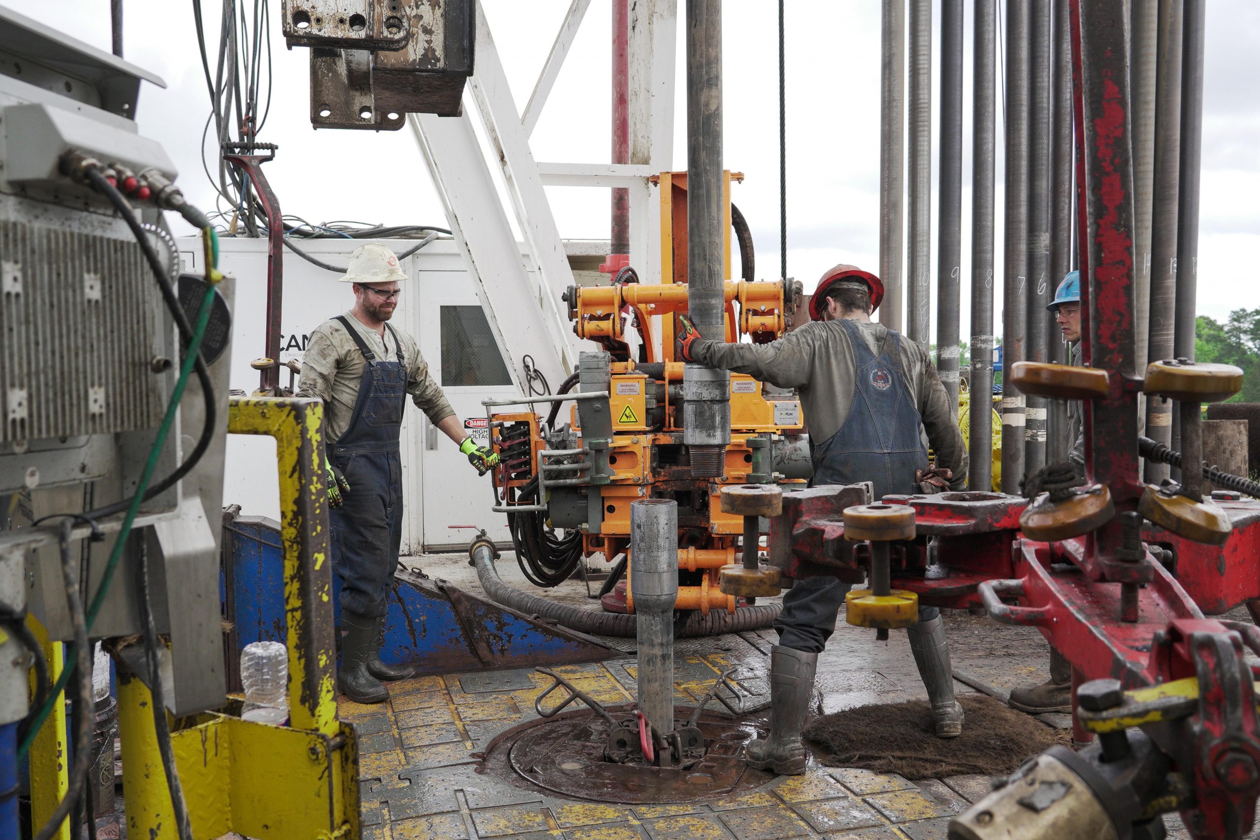 Workers on an oil rig at the drilling controls preparing to drill with an Ulterra Split Blade bit