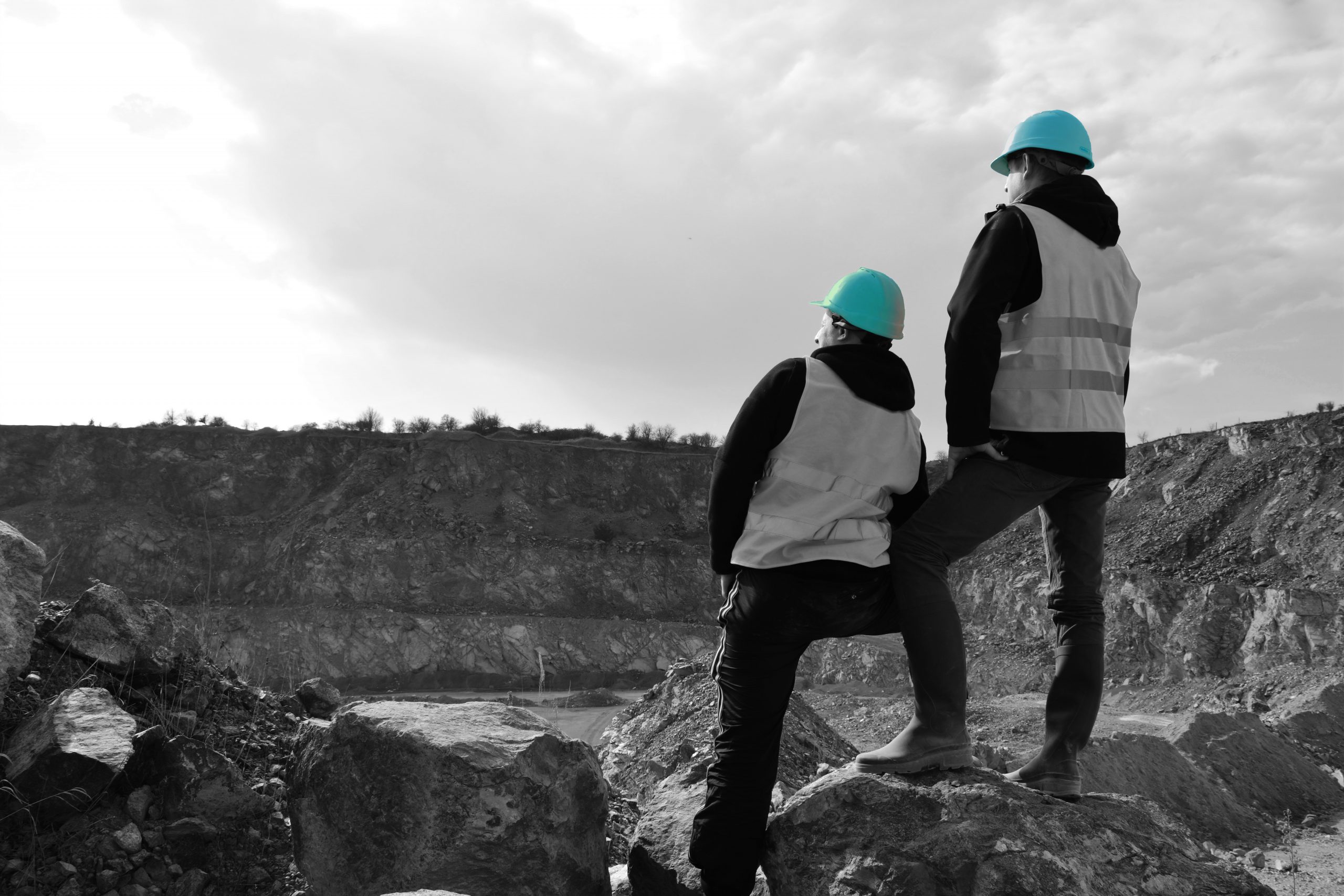 Two men in safety gear standing on rocks